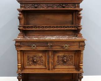 A late 19th French dining room buffet. Walnut construction featuring a carved crest over a molded backboard with an applied carved frieze, shelf and plate rail with turned supports on a molded base with inset Rouge Marble top, two carved silverware drawers and a lower cabinet with two paneled doors and applied foliate carvings flanked by fluted columns above an open well and molded base with bun feet. Older refinishing with some wear, minor damage, Marble repaired. 45 x 19 x 76 1/2" high overall.