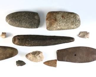 Ten Native American stone implements and fossils from the Great Lakes Region. Includes three adze heads, a gorget, celt, cache blade, three arrow heads and a section of two petrified teeth. Most from "Feldkamp Farm" in Saline, MI. Some wear. Up to 7 3/4" long.