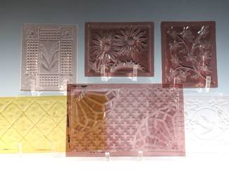 Six turn of the century American pressed glass window panes attributed to the Mosaic Glass Company, Fostoria, OH. Various floral, geometric and bird designs in Amethyst, Amber and clear. Some with minor flakes or small chips along edges. Up to 10" long.