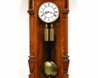 A 19th century Vienna Regulator wall clock by The Resch Brothers, Ebensee, Austria. 8-day weight driven time and strike movement with two-part porcelain dial with Roman numerals within a molded Brass bezel, serial #60399. Altdeutsch style Walnut case features a gallery crest over an arched door flanked by turned fluted pilasters with carved detail and shaped lower bracket. Older finish with minor wear, dial hairlines, not running when cataloged. 46" high overall.