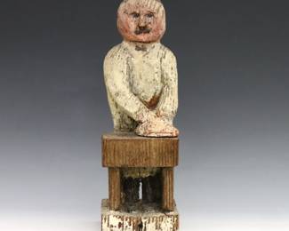 A 20th century American Folk Art carved wooden figure of a Baker with polychrome decoration. Wear and some shrinkage. 11" high.
