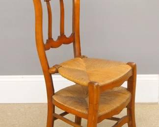 A 19th century Country French Prie Dieu chair. Cherry construction features a shaped arm rest with Brass owners plaque "Mme. P. Quillacq" above shaped molded splats, a rush lift-up seat and lower kneeler. Older refinishing with minor wear. 37" high.