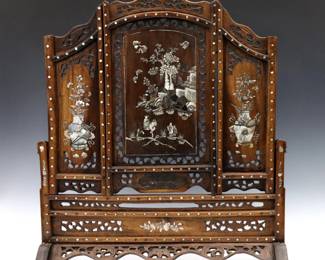 An early 20th century Chinese table screen. Carved Walnut frame with floral openwork design and inlaid Mother of Pearl scenes. Older finish with some wear, losses to inlay, minor damage. 27 x 7 1/4 x 30" high overall.