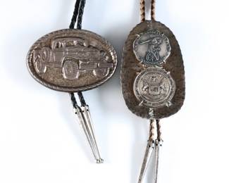 Two vintage Sterling Silver bolo ties. Includes a "Dodge Power Wagon" commemorative medal and two Michigan State University medallions with a hammered Sterling mount, on braided leather ties. Dodge medal incised "Sterling Silver", hammered mount tested Sterling, both with Silverplate aiguillettes. 9.60 troy ozs total. Some wear. Clasps up to 3 1/2" high, up to 22" long overall.