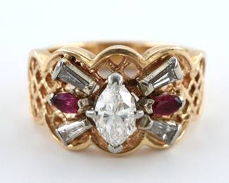 A vintage 14k Gold, Diamond and Ruby ring. Features a marquis cut prong set Diamond measuring 0.40 ct with I/J color, flanked by four Diamond baguettes with H/I color, and two marquis cut Rubies on a scalloped openwork band. Marked "14KT JE". 6.3 grams. Minor wear, center Diamond with slight VS1 to VS2 inclusions. Size 7 1/2.