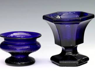 Two early 19th century American pattern molded open salts. Both Cobalt Blue glass, one with hexagonal shape and pedestal base, the other Boston & Sandwich Co. pattern GIII25 with "Sunburst in Square" decoration, flared rim and pedestal base. Hexagonal salt with surface wear and flakes. Up to 3 1/4" high.