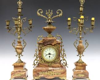 A turn of the century French three piece clock set. 8-day time only movement, porcelain dial marked "Louis Boon, Anvers" with Arabic numerals, serial #1769848. Louis XVI style Agate case with Gilded Bronze mounts and matching five light candelabra. Some wear and minor repairs, not running when cataloged. Up to 24" high overall.