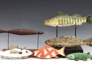 Six 20th century Folk Art fish decoys. Carved wooden bodies with polychrome decoration and aluminum or plastic fins. Wear and minor damage, longest with glued break to tail. Up to 9 1/4" long.