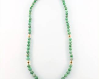 A Jade and 14k Gold necklace. Features sixty-eight Jade beads approx. 7.75 mm each, hand-knotted with twelve graduated 14k Gold spacer beads. Gold unmarked, tested 14k. 76.1 grams total. Minor wear, Gold beads with some small dents. 14" long.