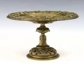 A late 19th century Continental Bronze tazza. Pierced Neoclassical design with foliate scrolls and masks on a draped baluster stem and circular foot. Wear and some oxidation. 10" diameter x 6" high.