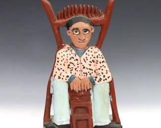 Elijah Pierce, American, 1892–1984. A late 20th century Folk Art wooden carving of a seated Black man. Signed "E. Pierce" with original label at underside. Glued repair to top, minor wear. 9 1/4" high.