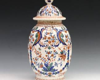 An 18th century Delft Earthenware covered jar. Polychrome floral decoration surrounded by geometric borders. Painted "APK" monogram mark. Some crazing and minor surface wear. 11 1/2" high.
