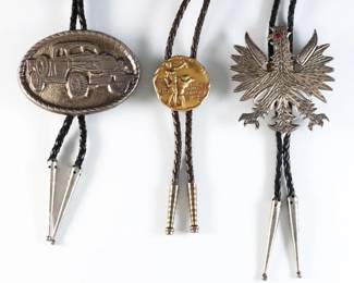 Three vintage Sterling Silver and 10k Gold Filled bolo ties. Includes a Sterling Polish style Eagle with gemstone eye, a Sterling "Dodge Power Wagon" commemorative medal and a 10k Gold Filled "National Collegiate Athletic Association" medallion, on braided leather ties. Marked or tested Sterling and 10k GF, Eagle tie with Sterling aiguillettes, Dodge tie with Silverplate aiguillettes. 7.45 troy ozs total, Sterling ties only. Some wear. Clasps up to 3" high, up to 22" long overall.