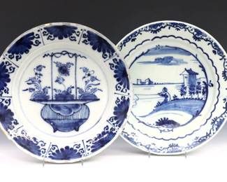 Two 18th century Delft Earthenware chargers. Blue and White landscape and flower basket decoration surrounded by floral borders. Fisherman charger with repair, flower basket charger with chips and painted touch ups along edges. Each 13 1/2" diameter.