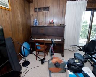 Vintage Foster & Co. upright player piano, microphone stands, recumbent exercise bike, treadmill
