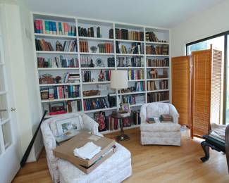 Upholstered club chairs and ottoman, lots of books, collectibles, louvered wooden standing screen, occasional / lamp table (and lamp!)