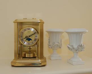 A Howard Miller carriage / mantle clock, and a pair of vintage Mottahedeh decorative ceramic campagna urns with applied fruit, flowers, and handles, made in Italy