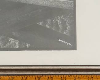Closeup of signature on signed black and white photograph of a photographer lying across a steel girder bridge, circa 1977