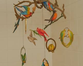 A handmade art piece mobile featuring colorful birds