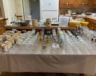 Miscellaneous kitchen glassware sets--counters around kitchen have dishes, glassware, cooking ware, etc.