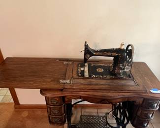 Antique sewing machine with push foot pumping pedal table