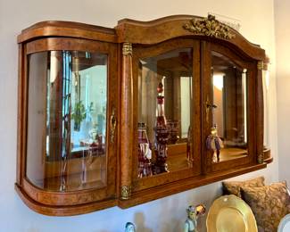 $800; vintage, wall-mounted curio with beveled glass and locking doors and gold metal leaf accents