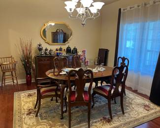 Dining table and buffet, rug, antique high chair, and home decor.