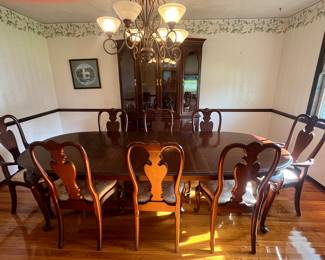 Dining table with full pads and eight chairs. Table measures 66 inches long and 43 inches wide by 30 inches tall. There are two additional leaves 18 inches for total table length of 8' 5”.