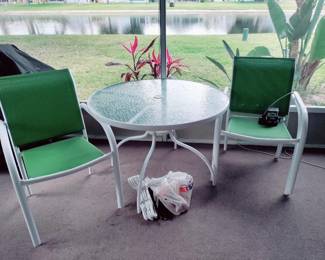 Small round glass Patio table with 4 green chairs