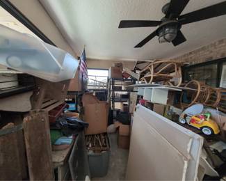 covered back porch. huge porch. has some rattan furniture, M&M toys, chests, and the rest is boxed and stacked and we can't see