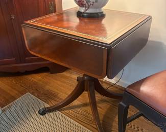 Duncan Phyfe style leather top four drop leaf pedestal accent table