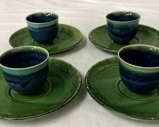 Four ceramic espresso or tea cups with matching saucers