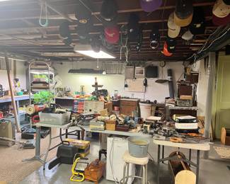 SO MUCH TO SEE IN BASEMENT. PLANTS IN LEFT OF PHOTO ARE NOT AVAILABLE. 2 CHAIN SAWS, ANTIQUE WOOD TOOL BOX, ANTIQUE FRUIT MARKET SCALE, MEAT GRINDER, BUTCHER BLOCK, 20 OF THE CAPS, ANTIQUE PRESSURE COOKERS