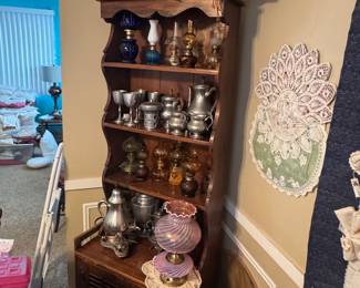 Open shelf vintage unit filled with Mini Glass Oil Lamps, Pewter, Fenton Boudoir Lamp & Textile "triangular" art on top