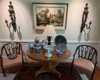 Pair of George III open back walnut armchairs, w/silk upholstery, antique heart pine oval table on brass casters, blue/white porcelain collection, bronze/marble table lamp, original oil on canvas and pair of antique French 2-light carved wood sconces, with angel and lion motif.