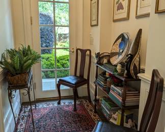 Lovely hallway of treasure off of the great room, with 3-shelf antique mahogany English bookshelf, w/ nice collection of gardening books, cast iron toys, 3-piece collection of Cosmic Clay straw-fired pottery, by TN artist, Christine Colombarini, set of fruit and botanical prints, pair of antique English side chairs, antique French wirework jardiniere plant stand, w/faux fern and hand-woven Persian Malayer rug.