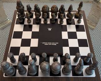 Rare 1962 Alcoa Aluminum "Alice In Wonderland" complete chess set, with original brochures, booklet titled "Before You Make the Next Move ask Alcoa" and all original boxes. The chess pieces represent characters from "Alice in Wonderland" in design authentic to the original "Through the Looking Glass" book by Lewis Carroll. Manufactured by the Aluminum Company of America (ALCOA). The pieces are nested in a 20" x 20" presentation box lined with red. Also included an original 19" x 19" aluminum board with 2" squares. The light pieces are in natural while the dark pieces are darkened aluminum.