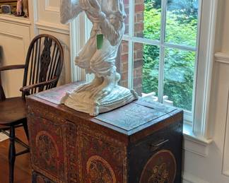 Artist-signed white glazed terra cotta juggling monkey on pillow, 1970, atop a hand-painted Tibetan blanket chest, with side handles.