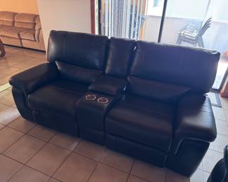 Dark Leather couch with electric reclining seats, cup holder and storage compartment
