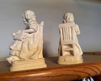 vintage chalkware bookend made by Alexander Backer Co. It depicts a Victorian girl sitting in a chair, holding a basket of flowers