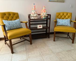 Groovy mustard yellow arm chairs, offset by blue and white accents pillows sofa flanking two ceramic trees on what-not stand