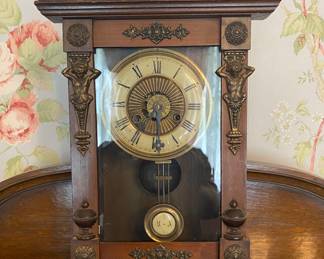Antique clock with pendulum & caryatid figures.
