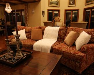 Large sofa with pillows, large coffee table with drawers, and decor