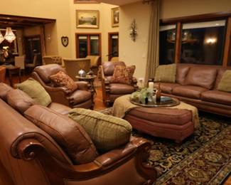 Soft, luxurious, and comfortable furniture: two leather sofas, two chairs, ottoman, wooden hand painted serving tray, pillows, rug, and decor