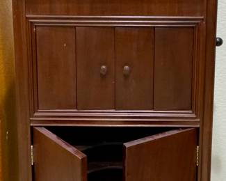 Columbia Grafonola, an early 20th-century (1907-1915) record player manufactured by the Columbia Graphophone Company. Features an internal horn concealed within a cabinet, designed to resemble fine furniture.
The cabinet includes louvred doors for volume control and hand-cranked spring motor.