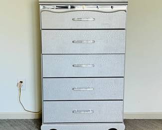 Zarollina Ashley Furniture 5-drawer high boy/dresser featuring Silver/gray finish accented by pearlized faux crocodile skin detailing, unique rhinestone handles and a mirrored accents.
measures 29.5 inches wide, 16 inches deep, 4 feet tall.