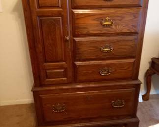 Wooden chest of drawers with decorative trim and brass handles