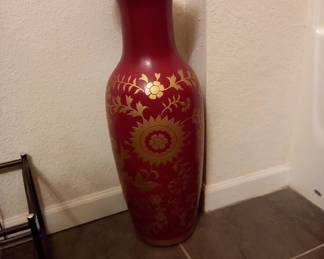 Tall red decorative vase with gold floral design