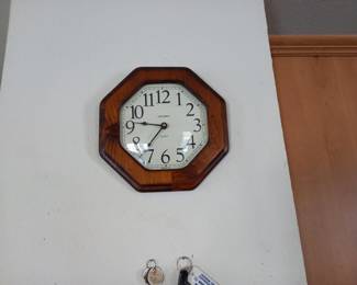 Classic octagonal wall clock with warm wooden frame. Features a clean white face with bold black numerals for easy reading. Timeless design that would complement any room's decor, from traditional to contemporary.Wall clock