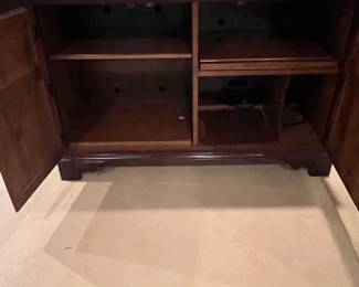 inside of the cabinet behind the doors - no drawers. Left side shelf adjusts, right side shelf pulls out to access and attach cords